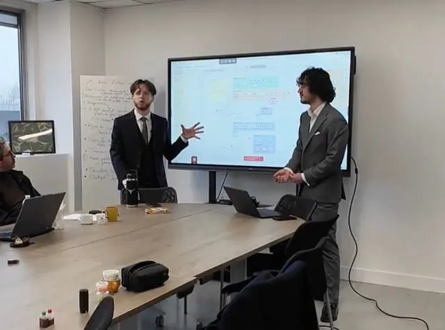 Les cofondateurs devant un workflow N8N en réunion client